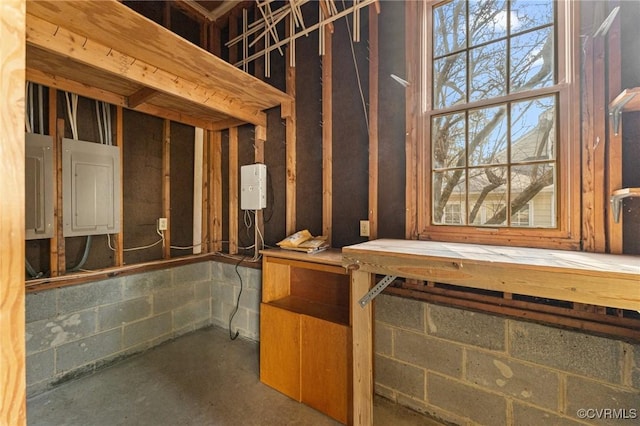 interior space with concrete flooring, a wealth of natural light, and electric panel