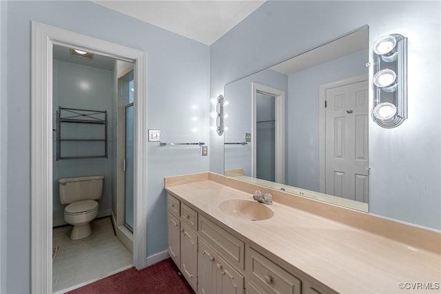 bathroom featuring vanity, a shower with shower door, and toilet