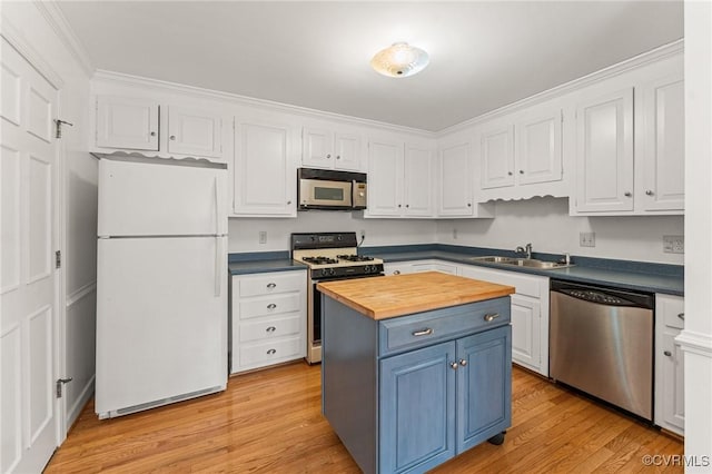 kitchen with white cabinetry, stainless steel appliances, sink, and wooden counters