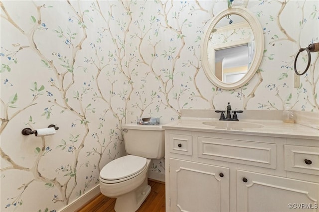 bathroom with wood-type flooring, toilet, and vanity