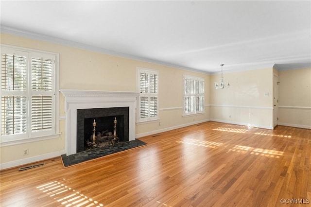 unfurnished living room featuring crown molding, a chandelier, and light wood-type flooring