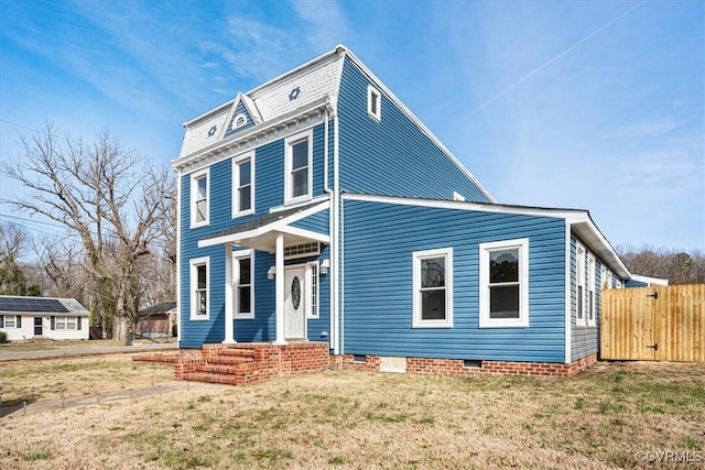 view of front of home with entry steps, a front yard, and fence