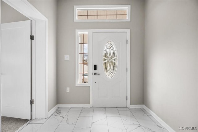 foyer with marble finish floor and baseboards