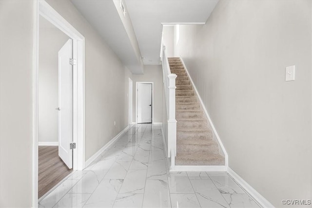 stairway with marble finish floor and baseboards