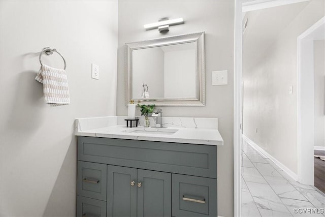 bathroom with marble finish floor, baseboards, and vanity