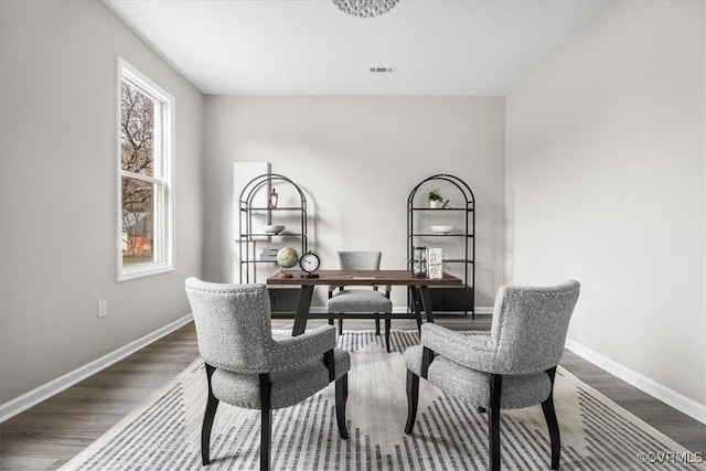 office space with dark wood-style flooring, visible vents, and baseboards