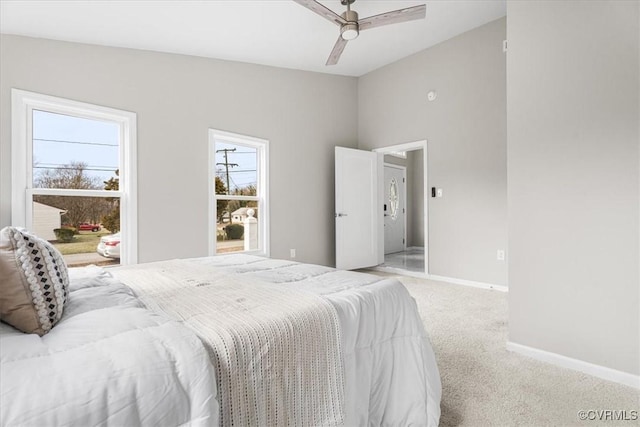 bedroom with light carpet, multiple windows, baseboards, and a ceiling fan