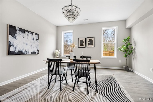 office space featuring a wealth of natural light, visible vents, baseboards, and an inviting chandelier