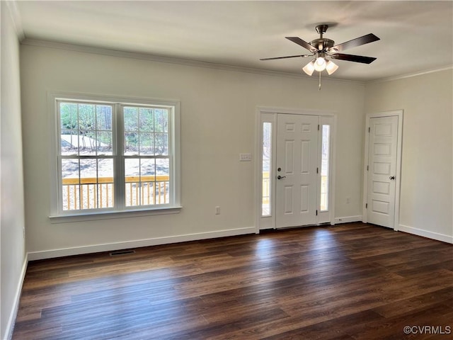 entrance foyer with ornamental molding, dark wood-type flooring, baseboards, and visible vents