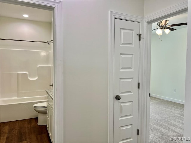 full bathroom featuring a ceiling fan, toilet,  shower combination, and baseboards