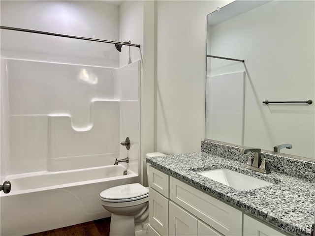 full bath featuring toilet, vanity, washtub / shower combination, and wood finished floors