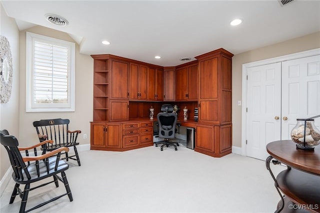 office space with light carpet and built in desk