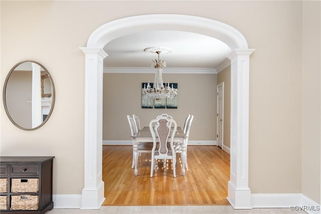 dining area with ornamental molding and decorative columns