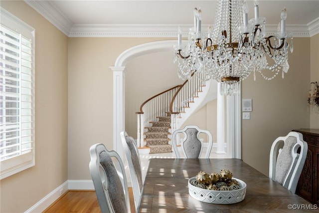 dining room with hardwood / wood-style floors, plenty of natural light, a chandelier, and ornate columns