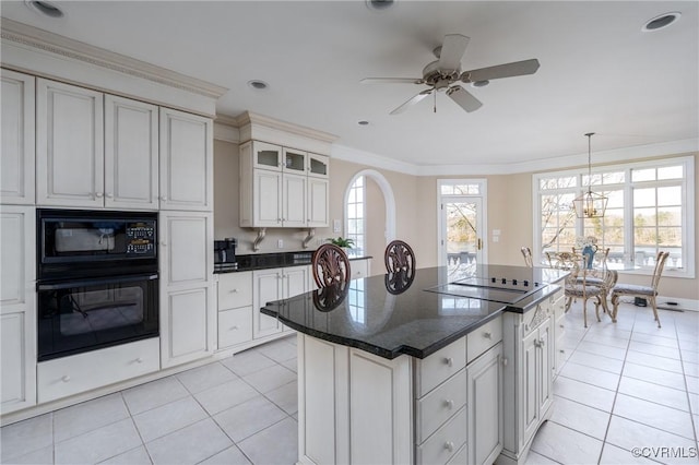 kitchen with white cabinets, a center island, light tile patterned floors, black appliances, and crown molding