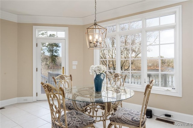 dining area with ornamental molding, a chandelier, and light tile patterned floors