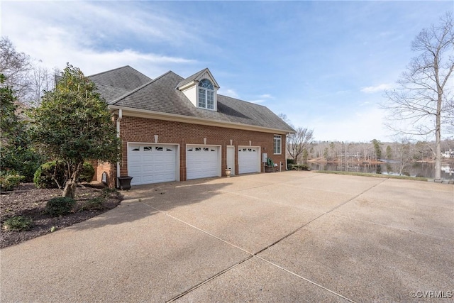 view of side of property featuring a garage and a water view