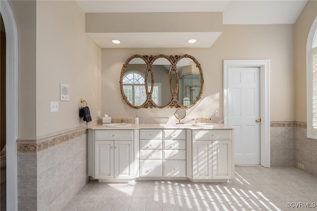 bathroom with tile walls, vanity, and tile patterned flooring