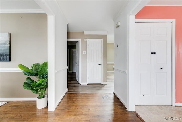 foyer entrance with crown molding and hardwood / wood-style flooring