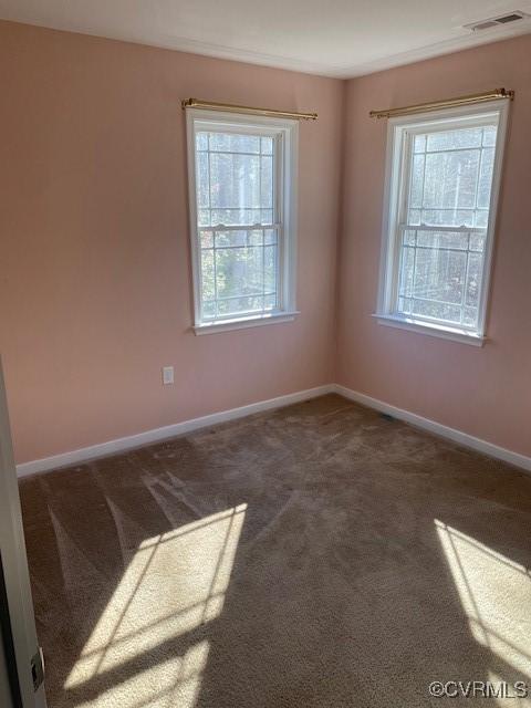 carpeted spare room featuring visible vents and baseboards