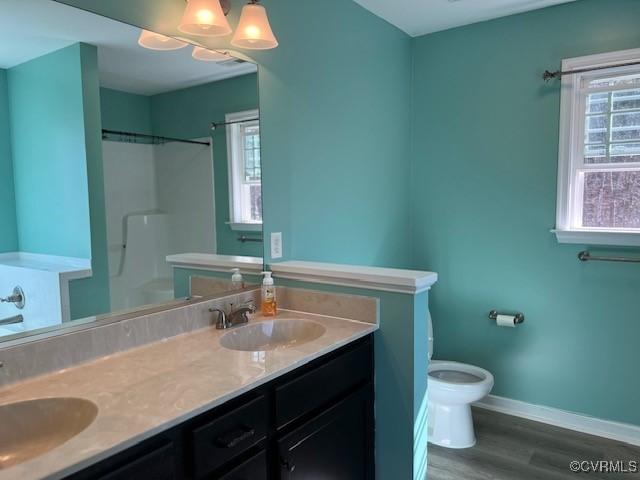 bathroom featuring a healthy amount of sunlight, toilet, and a sink