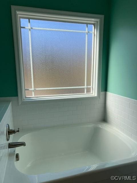 bathroom with plenty of natural light and a bath