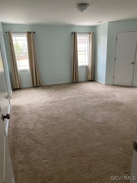 empty room featuring carpet floors and baseboards