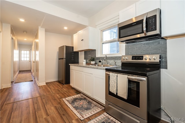 kitchen featuring backsplash, appliances with stainless steel finishes, sink, and white cabinets