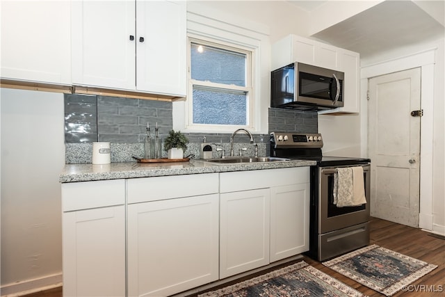 kitchen with sink, white cabinetry, appliances with stainless steel finishes, dark hardwood / wood-style floors, and decorative backsplash