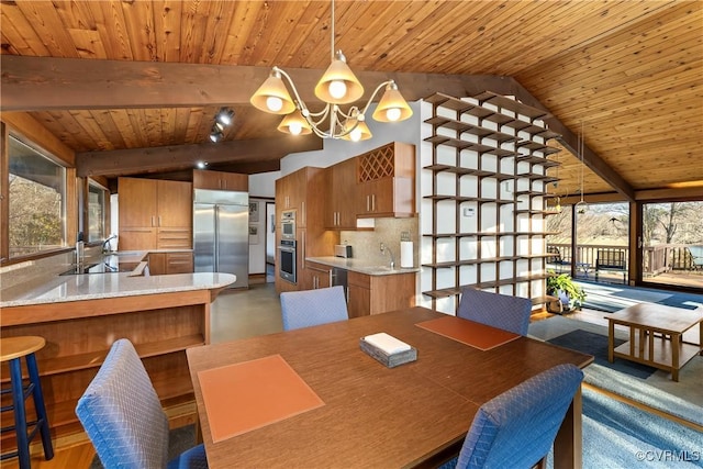 dining area featuring sink, a notable chandelier, wooden ceiling, and vaulted ceiling with beams