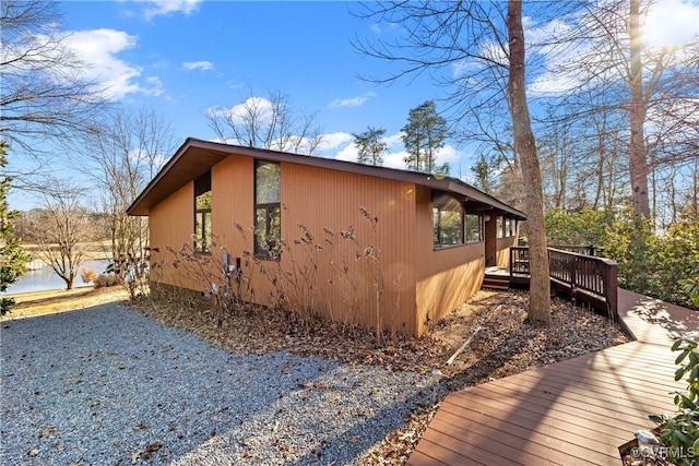 view of home's exterior featuring a deck with water view