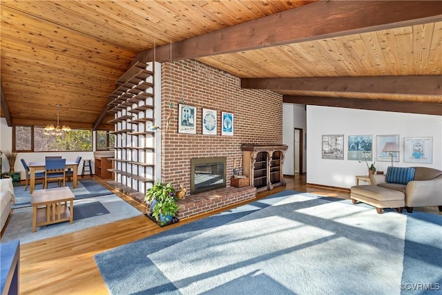 living room featuring hardwood / wood-style flooring, a brick fireplace, wooden ceiling, and an inviting chandelier