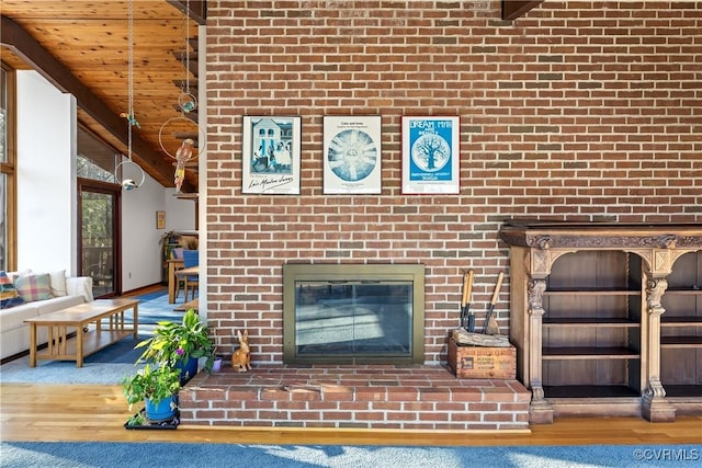 unfurnished living room featuring wood ceiling, a brick fireplace, beam ceiling, and hardwood / wood-style floors