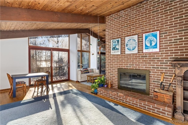 sunroom / solarium with wood ceiling, a brick fireplace, and vaulted ceiling with beams