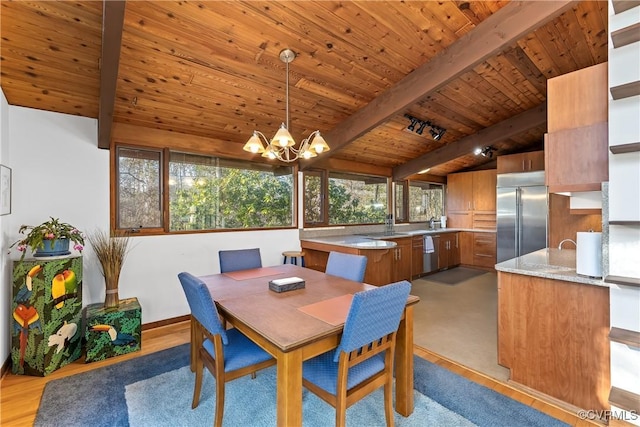 dining space with an inviting chandelier, wood ceiling, rail lighting, and beamed ceiling