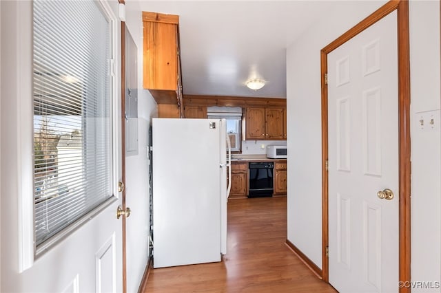 kitchen with white appliances and light hardwood / wood-style floors