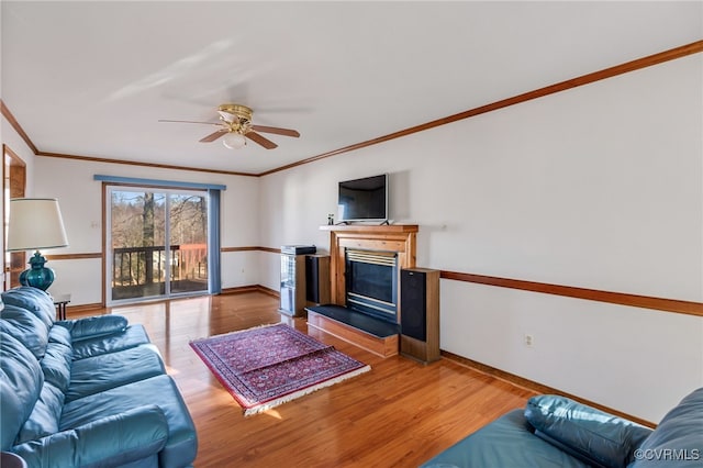 living room with hardwood / wood-style flooring, ceiling fan, and crown molding