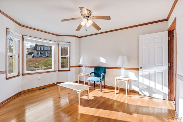 living area featuring crown molding, ceiling fan, and light hardwood / wood-style floors