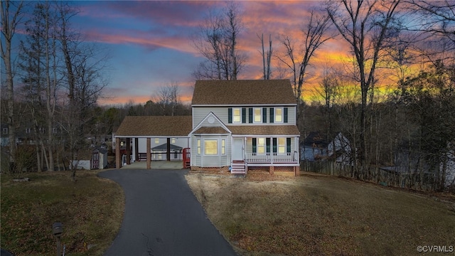 view of front of home featuring a carport, a yard, and covered porch