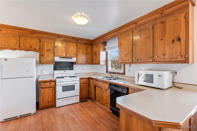 kitchen with white appliances, kitchen peninsula, sink, and light hardwood / wood-style flooring