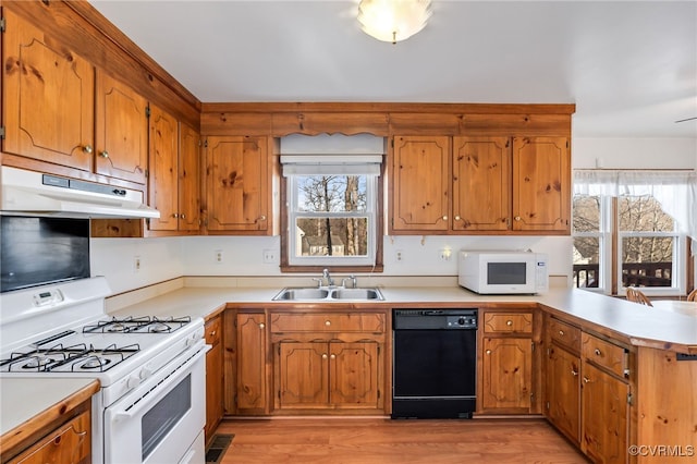 kitchen featuring sink, white appliances, light hardwood / wood-style floors, and kitchen peninsula