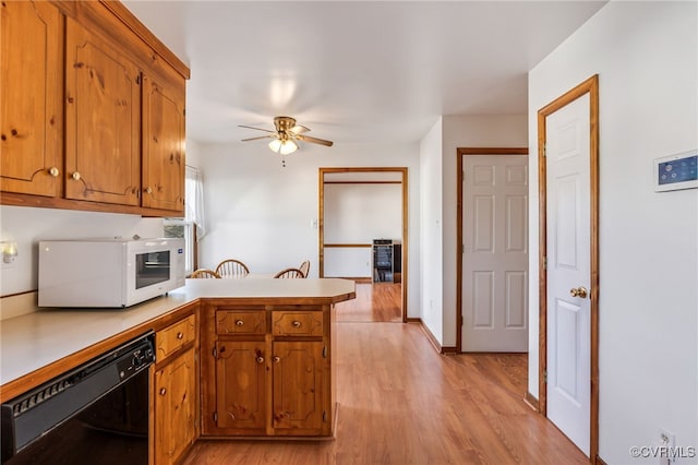 kitchen featuring ceiling fan, black dishwasher, light hardwood / wood-style floors, and kitchen peninsula