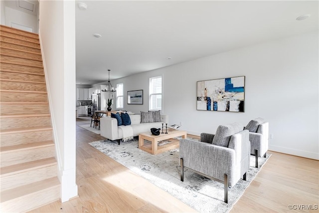 living room featuring a chandelier and light wood-type flooring