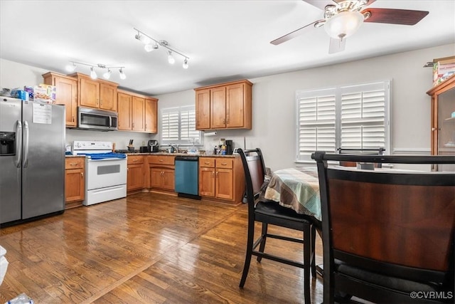 kitchen with stainless steel appliances, dark hardwood / wood-style floors, sink, and ceiling fan