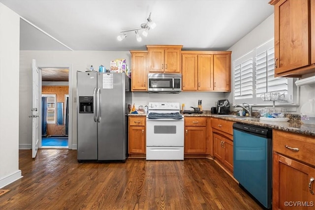 kitchen featuring appliances with stainless steel finishes, sink, and dark hardwood / wood-style flooring