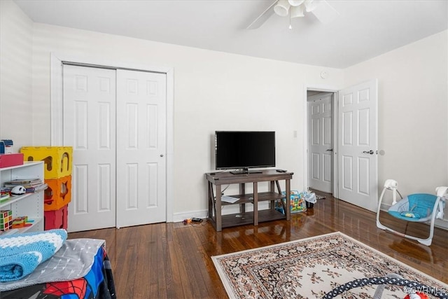 bedroom with dark wood-type flooring, ceiling fan, and a closet