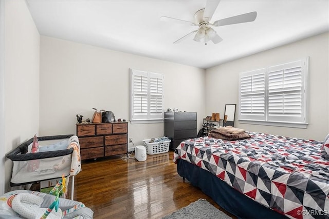 bedroom featuring multiple windows, dark hardwood / wood-style floors, and ceiling fan