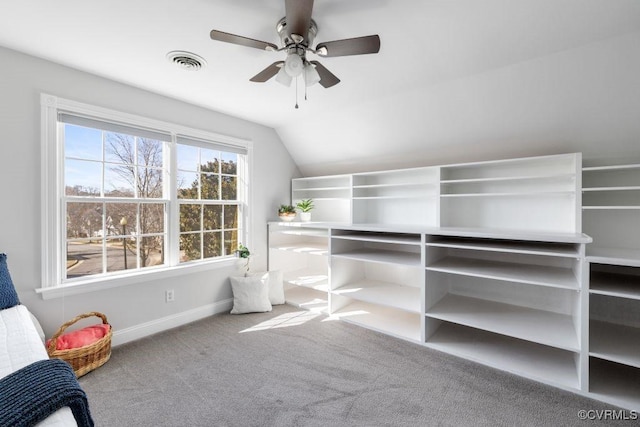 spacious closet with lofted ceiling, carpet floors, and ceiling fan