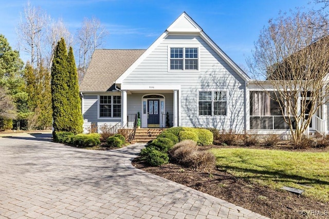 view of front of house with a sunroom and a front yard