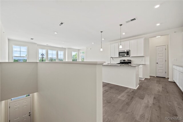 3817 Maze Runner Dr, Midlothian, VA 23112 - kitchen with white cabinetry, hanging light fixtures, stainless steel appliances, light stone countertops, and a center island with sink